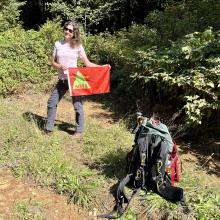 Myself holding a SOTA flag at the side of the gravel road